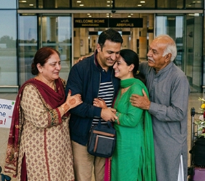 Happy overseas Pakistani family hugging during a reunion at the airport representing a specialized family reunion tour package